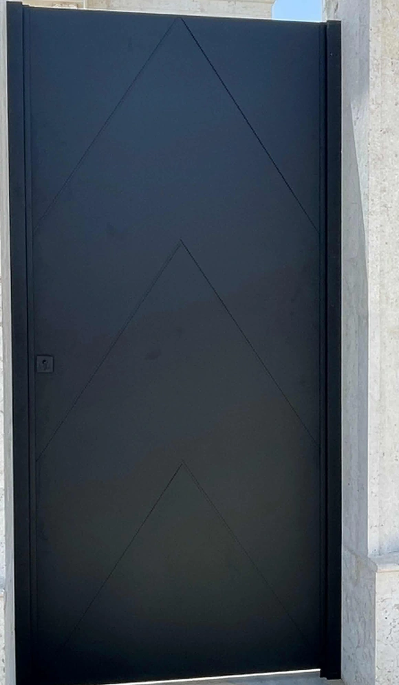 A dark door with subtle angular chevron lines across the main panel.