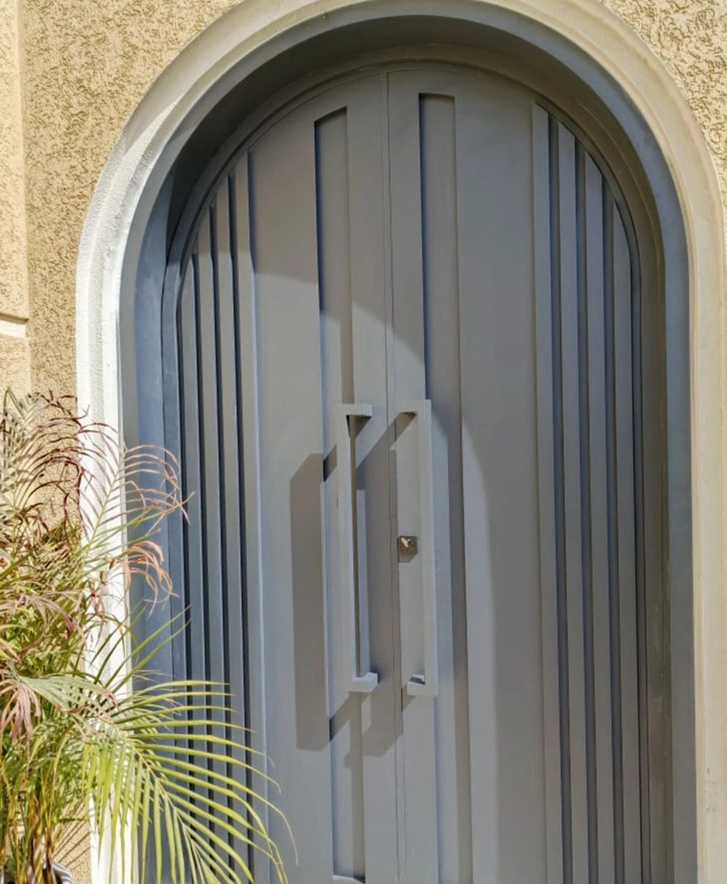 A rounded double-door entrance with vertical panel detailing and paired pull handles.