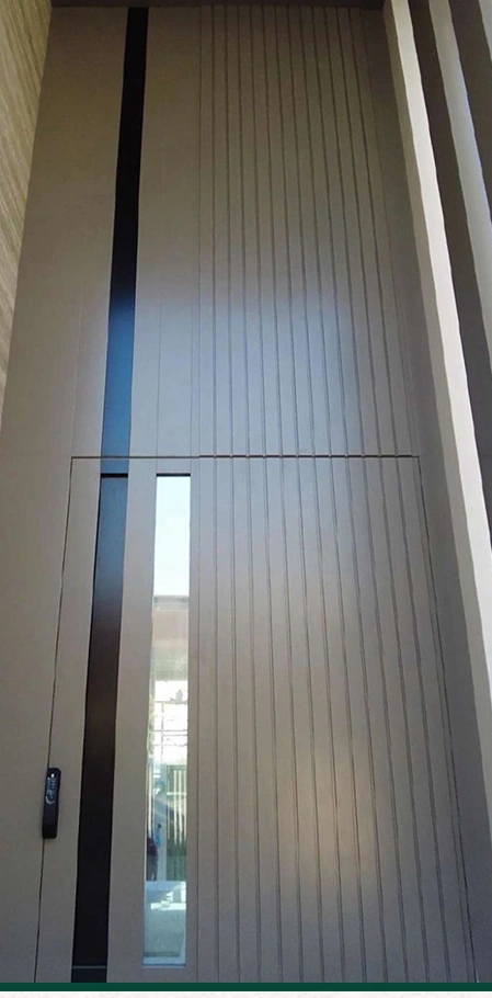 A full-height dark ribbed entrance with a slim vertical glazed detail.
